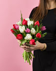 Hand haelt Tulpenstrauss Weiss-Rosa-Rot Mix