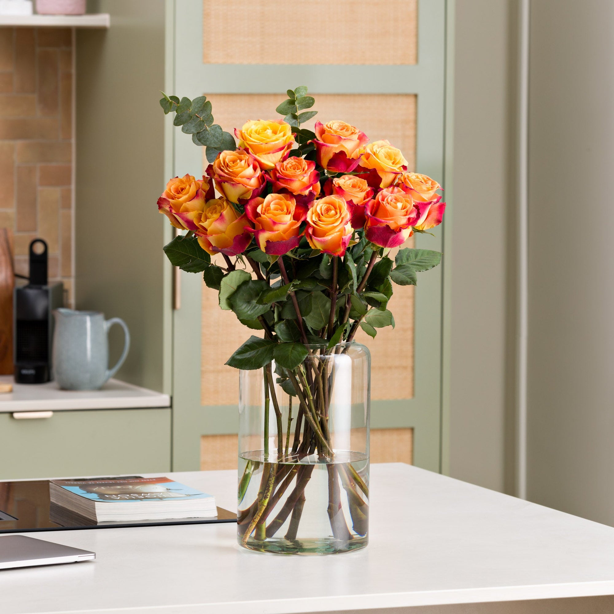 Oranger Rosenstrauß in Vase in der Küche