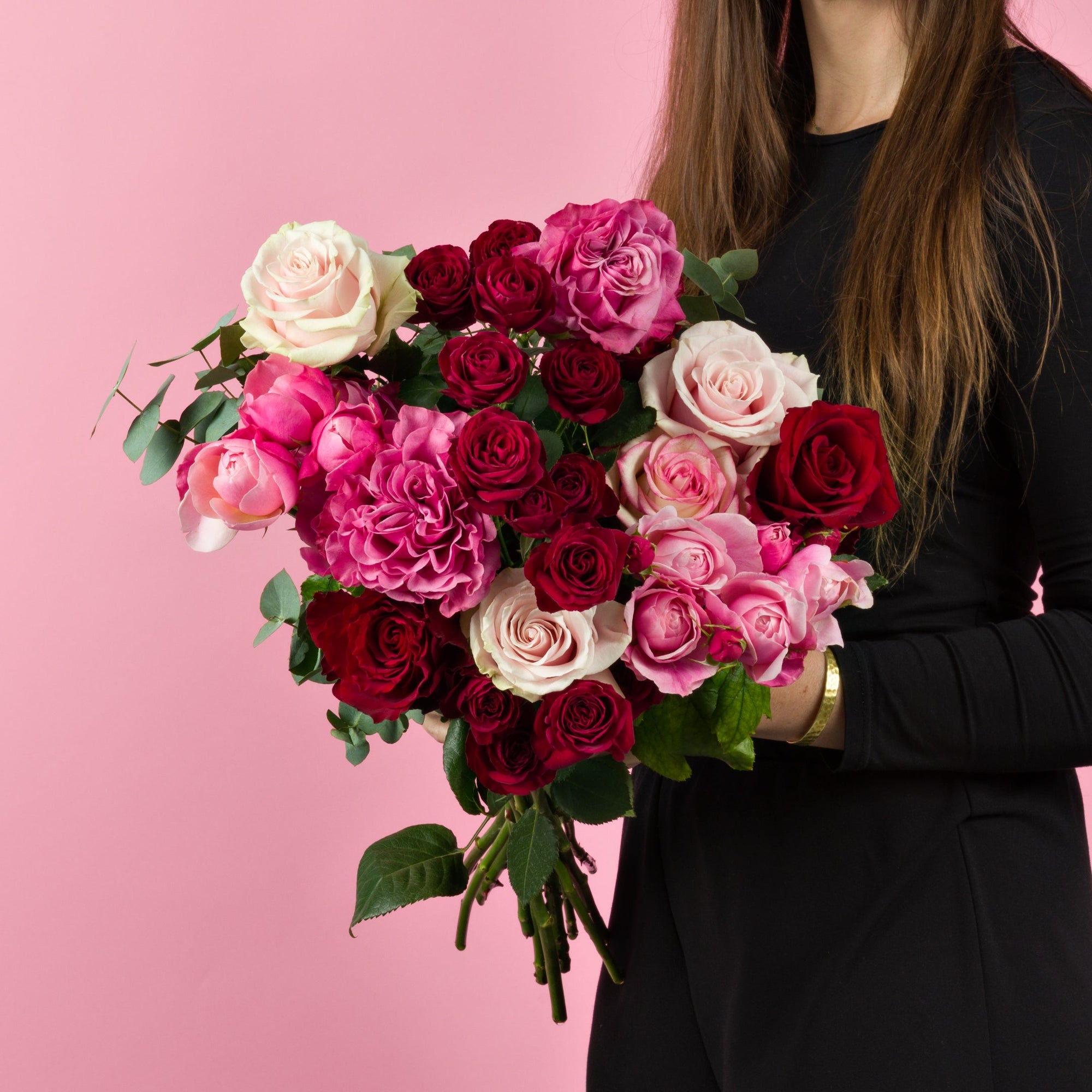 Hand haelt Rosenstrauss mit Sprayrosen Rosa-Rot
