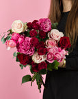 Hand haelt Rosenstrauss mit Sprayrosen Rosa-Rot